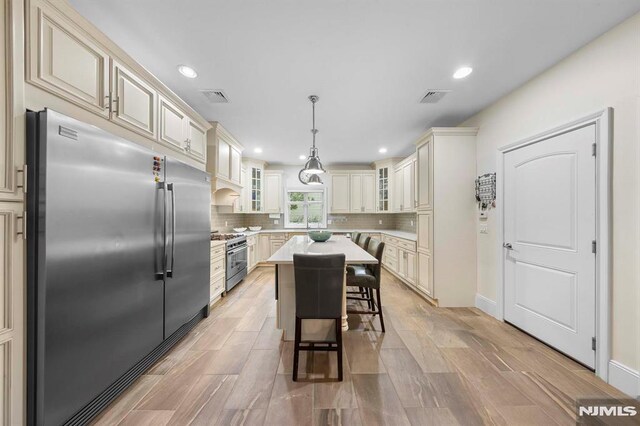 66 Andover Ter, Glen Rock, NJ 07452 - kitchen with high quality appliances, cream cabinets, light countertops, tasteful backsplash, and recessed lighting