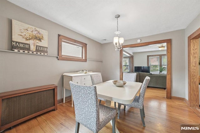 350 Walnut St, Nutley, NJ 07110 - dining space featuring radiator heating unit, light wood-style flooring, and a chandelier