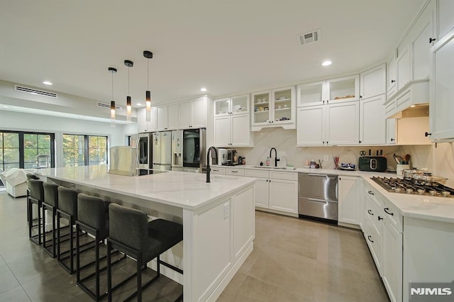 258 County Rd, Demarest, NJ 07627 - kitchen with appliances with stainless steel finishes, decorative backsplash, white cabinetry, a large island with sink, and recessed lighting