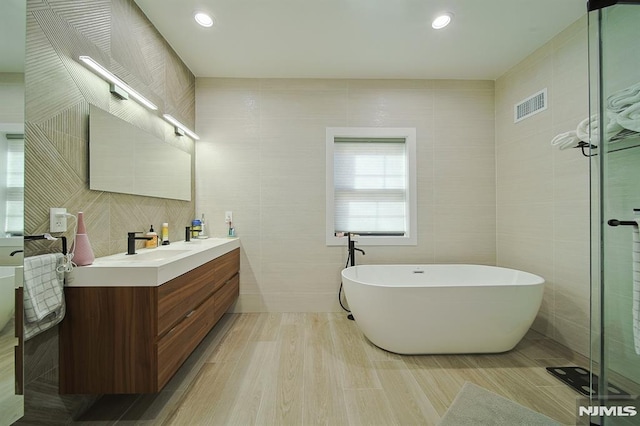 258 County Rd, Demarest, NJ 07627 - bathroom featuring tile walls, vanity, and a soaking tub