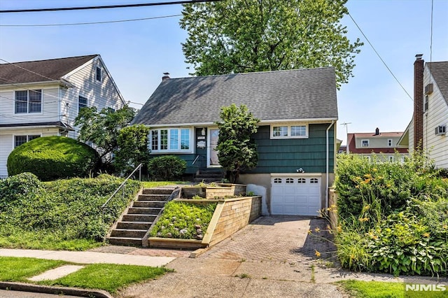 459 Washington Ave, Rutherford, NJ 07070 - view of front of home with decorative driveway, an attached garage, a shingled roof, and a vegetable garden
