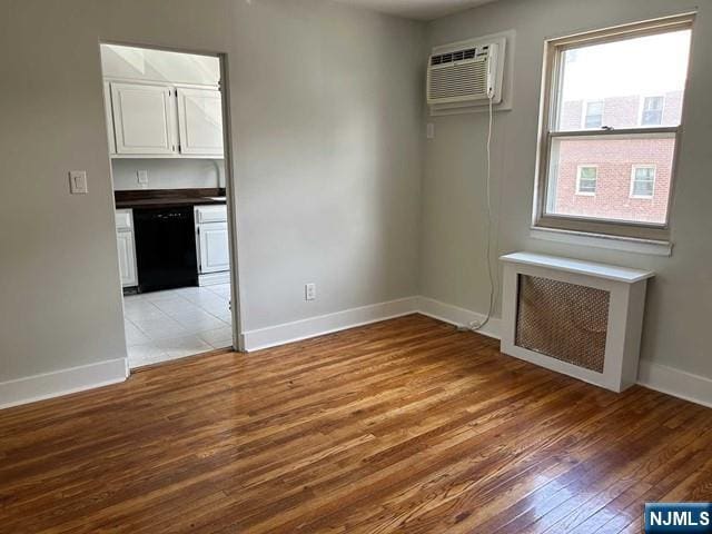 125 E Clinton Unit 10B, Bergenfield, NJ 07621 - empty room with radiator, a wall unit AC, and light wood-type flooring
