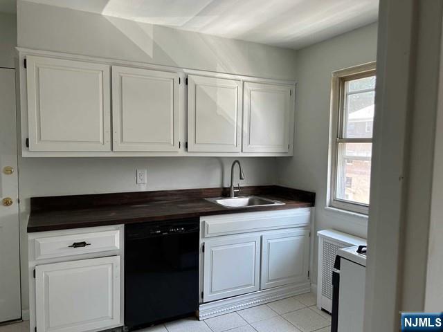 125 E Clinton Unit 10B, Bergenfield, NJ 07621 - kitchen with black dishwasher, dark countertops, white cabinets, and light tile patterned floors