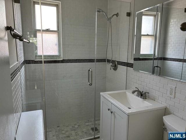 125 E Clinton Unit 10B, Bergenfield, NJ 07621 - bathroom with vanity, plenty of natural light, a shower stall, and tile walls
