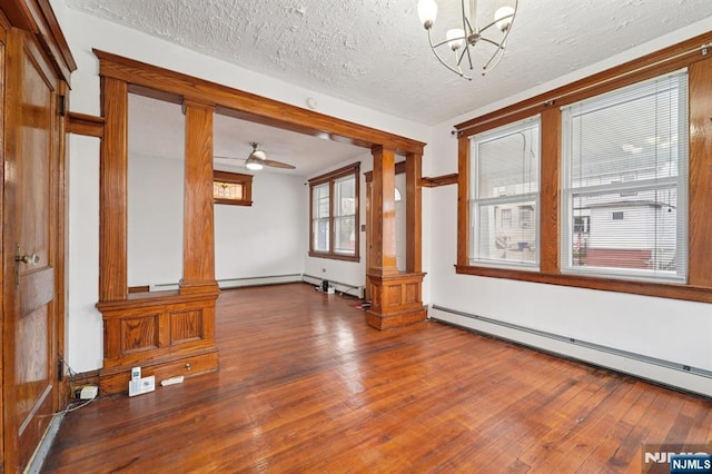 174-176 Albion Ave, Paterson, NJ 07502 - spare room featuring ornate columns, baseboard heating, wood-type flooring, and a textured ceiling