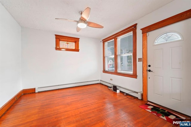 174-176 Albion Ave, Paterson, NJ 07502 - entrance foyer with a baseboard heating unit, healthy amount of natural light, a ceiling fan, and wood finished floors