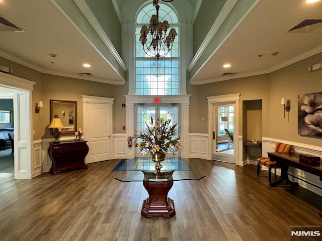 7207 Ravenscroft Rd Unit 7207, Clifton, NJ 07013 - dining area with a chandelier, a decorative wall, dark wood-style flooring, a wainscoted wall, and a high ceiling