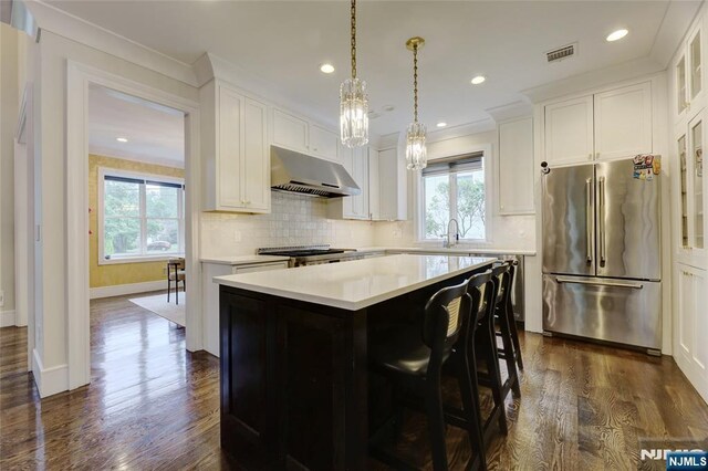 62 Merritt Ave, Cresskill, NJ 07626 - kitchen featuring high end fridge, exhaust hood, a kitchen island, light countertops, and dark wood-type flooring