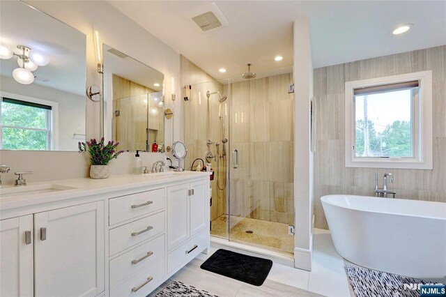 62 Merritt Ave, Cresskill, NJ 07626 - full bathroom with a shower stall, a soaking tub, double vanity, recessed lighting, and tile patterned flooring