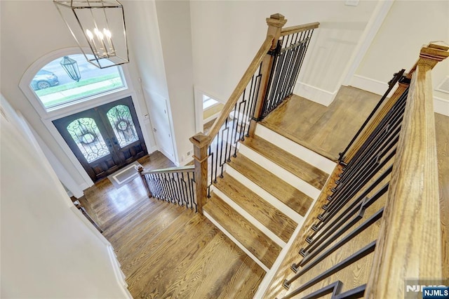 62 Merritt Ave, Cresskill, NJ 07626 - foyer featuring wood finished floors, a chandelier, french doors, stairway, and a towering ceiling