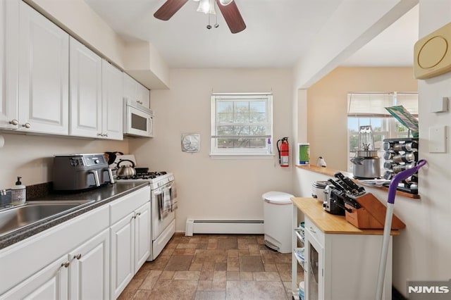 1245 Valley Rd Unit B, Wayne, NJ 07470 - kitchen with a baseboard heating unit, white appliances, stone finish flooring, ceiling fan, and white cabinetry