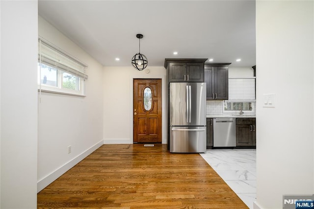 69 Lorraine Dr, Clifton, NJ 07012 - kitchen featuring appliances with stainless steel finishes, decorative backsplash, light marble finish flooring, recessed lighting, and light countertops