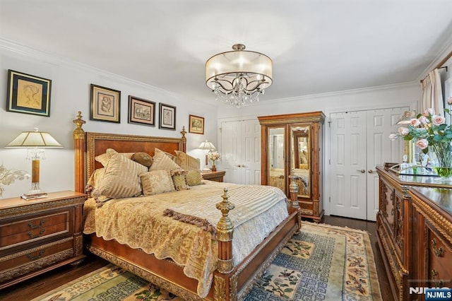 15 Barberry Way, Essex Fells, NJ 07021 - bedroom featuring multiple closets, dark wood-type flooring, a chandelier, and ornamental molding