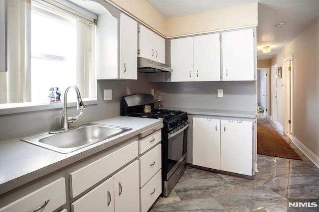 131 Shaler Ave, Fairview, NJ 07022 - kitchen with stainless steel gas range, under cabinet range hood, light marble finish flooring, light countertops, and white cabinetry