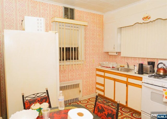 5 Grove St, Bloomfield, NJ 07003 - kitchen featuring white appliances, radiator heating unit, crown molding, wallpapered walls, and light countertops