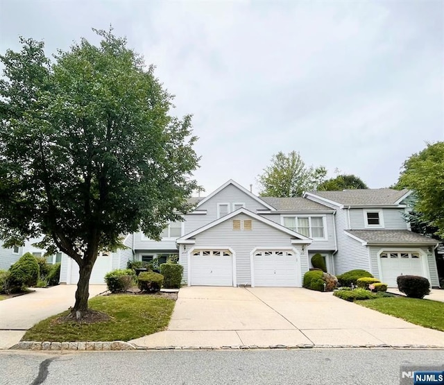 214 Manahan Rd Unit 214, East Brunswick, NJ 08816 - view of front of home featuring concrete driveway, a garage, and a shingled roof