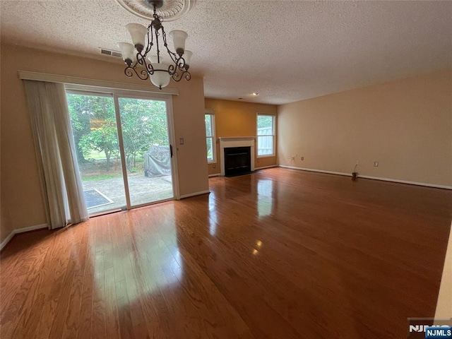 214 Manahan Rd Unit 214, East Brunswick, NJ 08816 - unfurnished living room featuring wood finished floors, a textured ceiling, a chandelier, and a fireplace