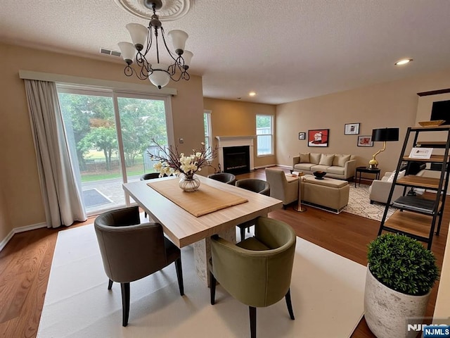 214 Manahan Rd Unit 214, East Brunswick, NJ 08816 - dining room featuring wood finished floors, a fireplace, a chandelier, recessed lighting, and a textured ceiling