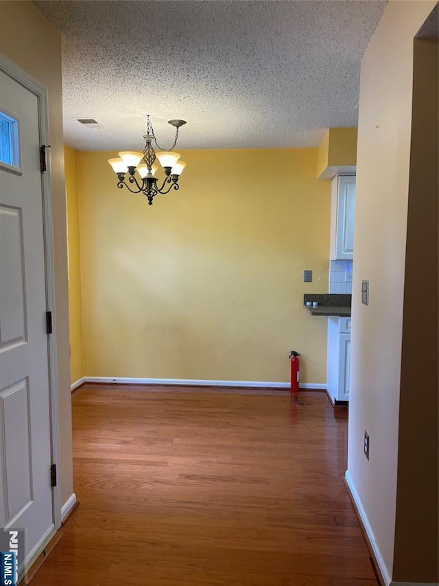 214 Manahan Rd Unit 214, East Brunswick, NJ 08816 - hall featuring a chandelier, wood finished floors, and a textured ceiling