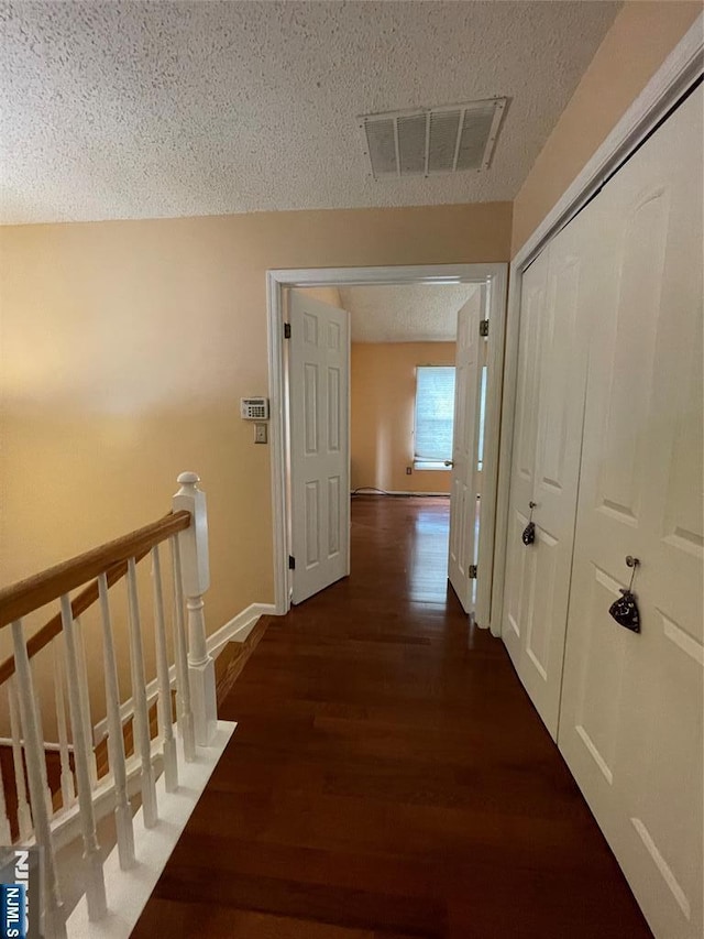 214 Manahan Rd Unit 214, East Brunswick, NJ 08816 - hallway with dark wood finished floors, a textured ceiling, and an upstairs landing
