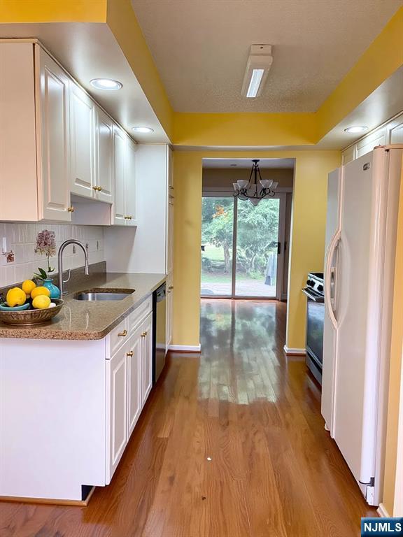 214 Manahan Rd Unit 214, East Brunswick, NJ 08816 - kitchen featuring freestanding refrigerator, white cabinetry, a chandelier, stainless steel range oven, and recessed lighting