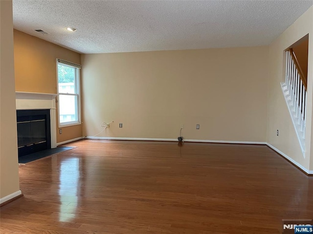 214 Manahan Rd Unit 214, East Brunswick, NJ 08816 - unfurnished living room featuring a textured ceiling, wood finished floors, and a fireplace with flush hearth