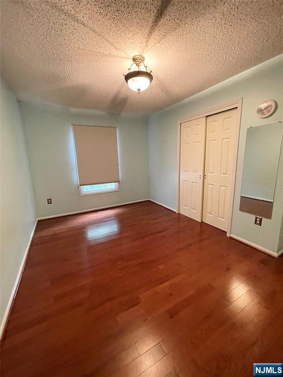 214 Manahan Rd Unit 214, East Brunswick, NJ 08816 - unfurnished bedroom with a closet, wood finished floors, and a textured ceiling