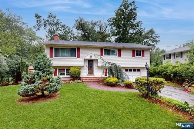10 W Lake Dr, Byram, NJ 07874 - raised ranch with asphalt driveway, a chimney, an attached garage, and a front yard