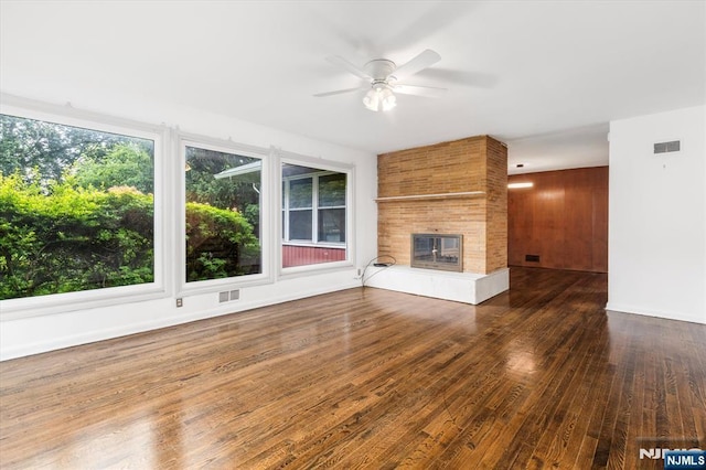 243 Lafayette Ave, Passaic, NJ 07055 - unfurnished living room with a ceiling fan, wood-type flooring, and a tiled fireplace