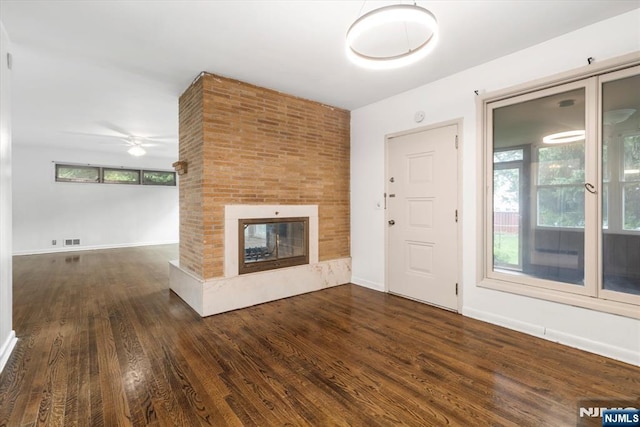 243 Lafayette Ave, Passaic, NJ 07055 - unfurnished living room with wood finished floors, ceiling fan, a multi sided fireplace, and plenty of natural light