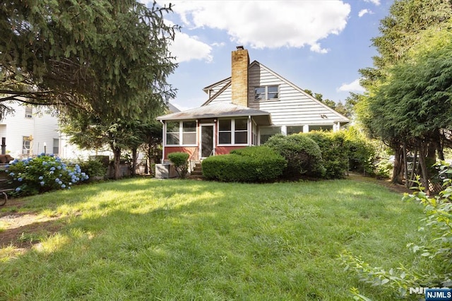 243 Lafayette Ave, Passaic, NJ 07055 - view of front of property with a chimney, a sunroom, and a front yard