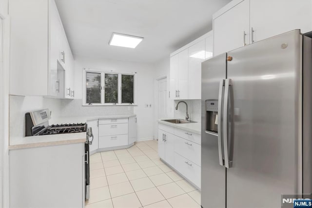 243 Lafayette Ave, Passaic, NJ 07055 - kitchen with stainless steel appliances, light countertops, white cabinets, and light tile patterned flooring