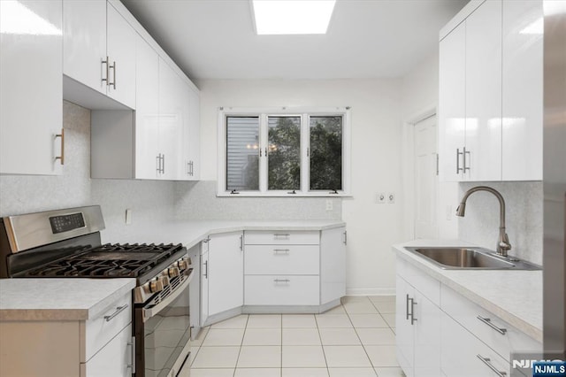 243 Lafayette Ave, Passaic, NJ 07055 - kitchen with stainless steel gas range, tasteful backsplash, light countertops, light tile patterned flooring, and white cabinetry