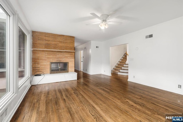 243 Lafayette Ave, Passaic, NJ 07055 - unfurnished living room featuring ceiling fan, stairs, wood finished floors, and a multi sided fireplace