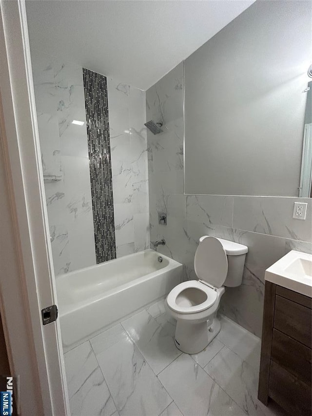 61 Grove, East Orange, NJ 07017 - bathroom with marble look tile flooring, vanity, washtub / shower combination, and tile walls
