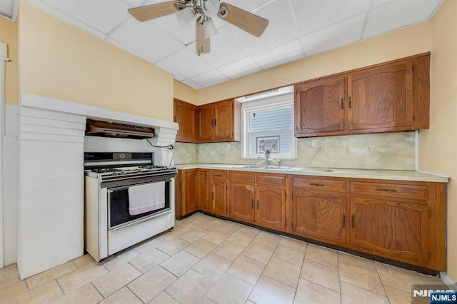 407 Elm St, Kearny, NJ 07032 - kitchen featuring white range with gas stovetop, a drop ceiling, light countertops, brown cabinets, and decorative backsplash