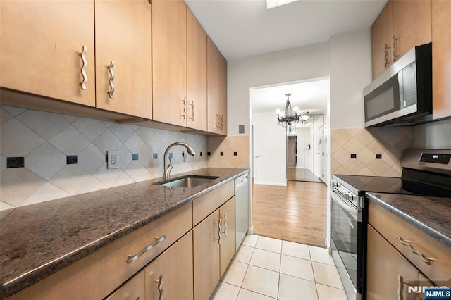 9019 Wall St Unit 6B, North Bergen, NJ 07047 - kitchen with appliances with stainless steel finishes, a chandelier, light tile patterned floors, and tasteful backsplash