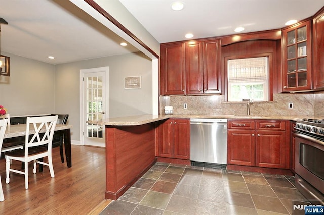 393 High St, Nutley, NJ 07110 - kitchen with stainless steel appliances, a peninsula, recessed lighting, tasteful backsplash, and glass insert cabinets