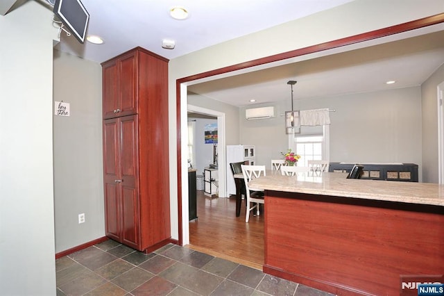 393 High St, Nutley, NJ 07110 - kitchen featuring a wall mounted AC, recessed lighting, pendant lighting, light stone counters, and dark stone finish flooring