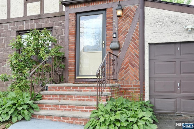 393 High St, Nutley, NJ 07110 - view of exterior entry featuring brick siding and a garage