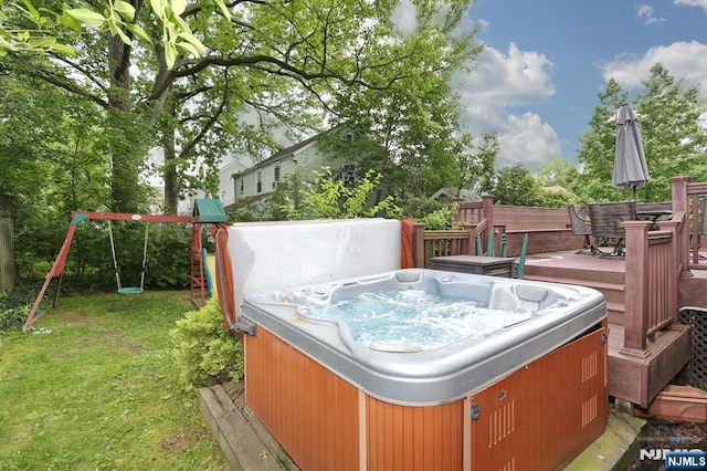 393 High St, Nutley, NJ 07110 - view of grassy yard with a hot tub, a wooden deck, outdoor dining area, and a playground