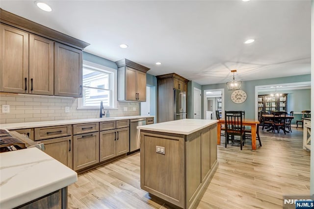 19 Mountain Rdg, Wayne, NJ 07470 - kitchen with appliances with stainless steel finishes, backsplash, light wood finished floors, a kitchen island, and light stone countertops