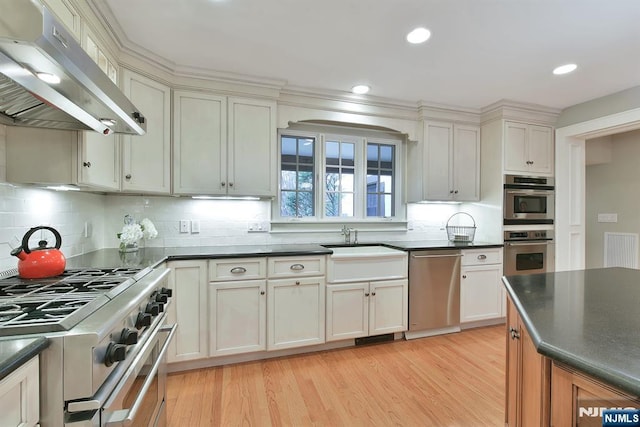 152 Highwood Ave, Tenafly, NJ 07670 - kitchen with ventilation hood, appliances with stainless steel finishes, dark countertops, light wood finished floors, and recessed lighting