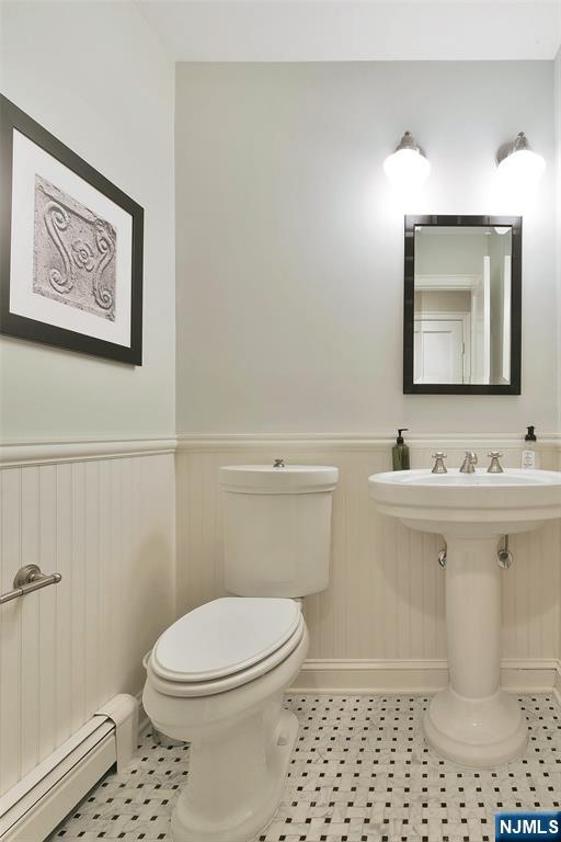 152 Highwood Ave, Tenafly, NJ 07670 - bathroom with baseboard heating and a wainscoted wall