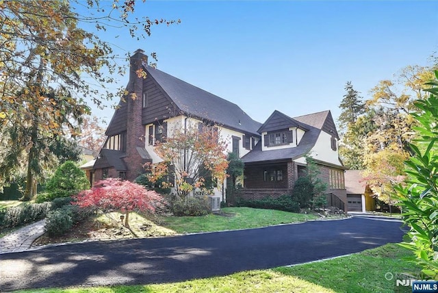 152 Highwood Ave, Tenafly, NJ 07670 - view of front of house featuring a front lawn, brick siding, and a chimney
