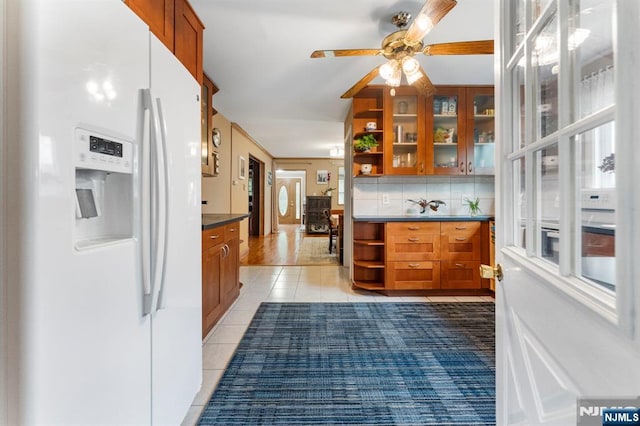 159 Oak Ridge Rd, West Milford, NJ 07438 - kitchen featuring white refrigerator with ice dispenser, open shelves, brown cabinetry, dark countertops, and light tile patterned floors