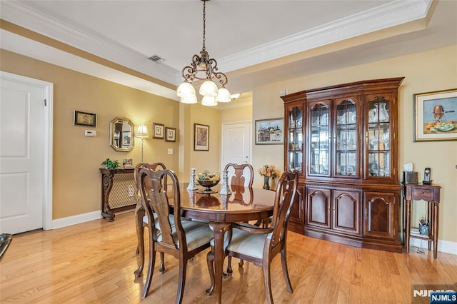 7108 Ravenscroft Rd Unit 555, Clifton, NJ 07013 - dining space featuring a chandelier, ornamental molding, light wood-type flooring, and a raised ceiling