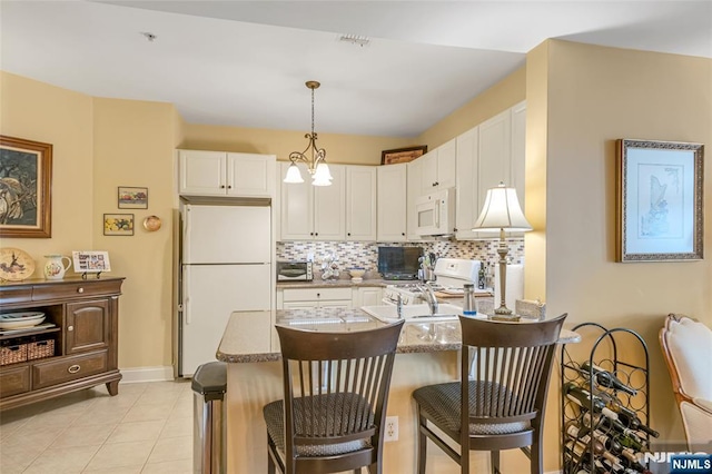 7108 Ravenscroft Rd Unit 555, Clifton, NJ 07013 - kitchen with white appliances, a peninsula, white cabinetry, and decorative backsplash