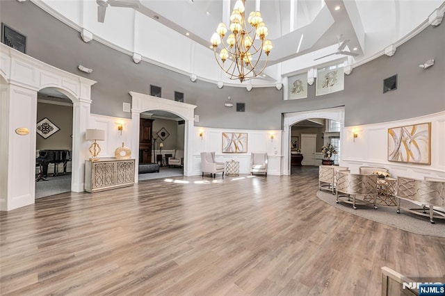 7108 Ravenscroft Rd Unit 555, Clifton, NJ 07013 - living area with a towering ceiling, arched walkways, a decorative wall, and light wood-style flooring