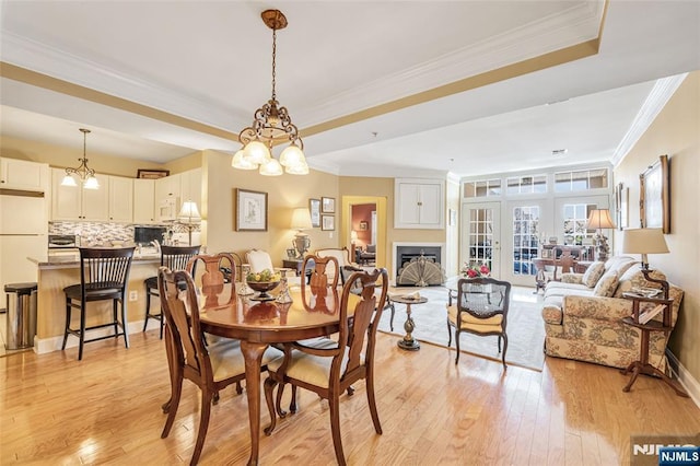 7108 Ravenscroft Rd Unit 555, Clifton, NJ 07013 - dining area with ornamental molding, a tray ceiling, light wood-type flooring, a fireplace, and a chandelier